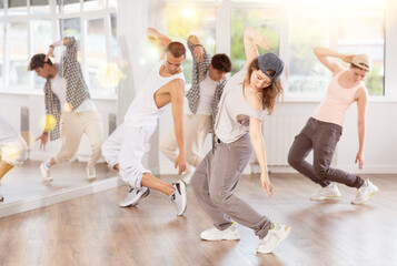 Active young girl practicing break dance in training hall during dancing classes