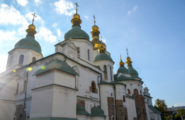Majestic Orthodox cathedral, St. Sophia's in Kyiv, with its iconic green domes and golden cupolas gleaming under a blue sky with soft clouds