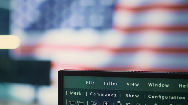Empty high tech office with a big screen showing an American flag, representing cybersecurity operations. Encryption, malware detection and security protocols to ensure data security. Camera B.