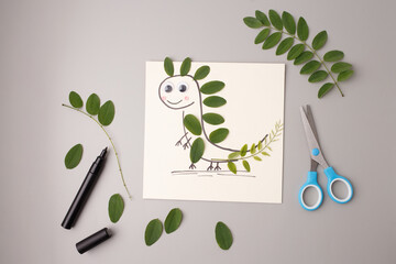 DIY dinosaur art project using real leaves and marker drawing on paper, ideal for children crafts,...