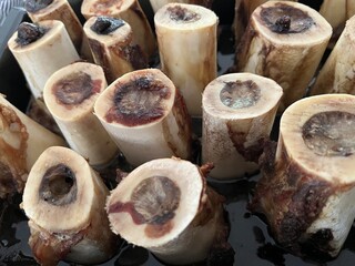 Closeup photo of roasted bone marrow with focused on the center of the baking tray.