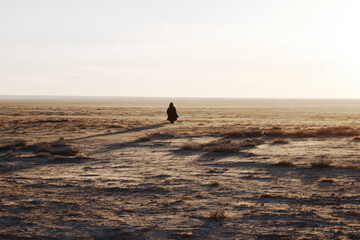 minimalist scene of solitary sculpture on edge of argentine steppe long shadows cast by low sun highlighting
