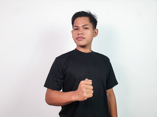A confident Asian man stands against a white background wearing a black shirt and making a decisive...