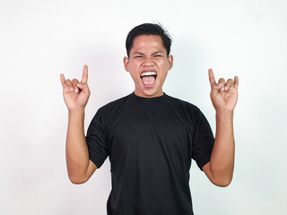 Happy Young Asian Man in Black Shirt Smiling and Showing Rock Gesture on White Background