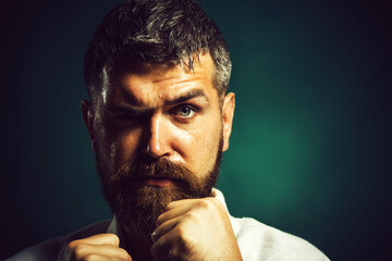 Closeup portrait of karate man with clenched fists. Professional karate fighter in kimono before...