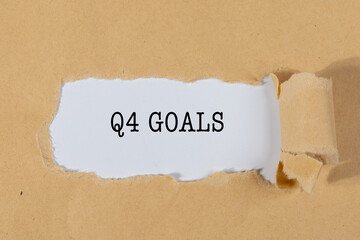 The Text “THE Q4 GOALS” Appearing Behind Torn Brown Paper – Business Planning Concept
