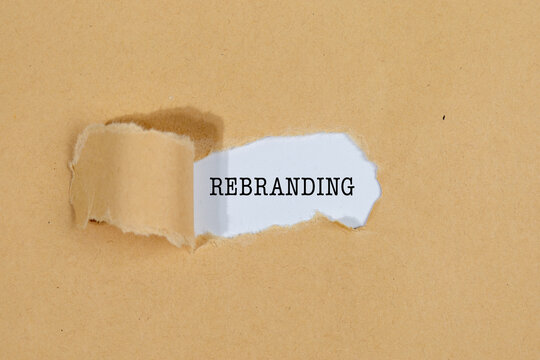The Text &ldquo;REBRANDING&rdquo; Appearing Behind Torn Brown Paper &ndash; Business Strategy Concept
