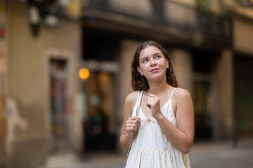 Young woman in white dress walking along the streets of the historical center of the city