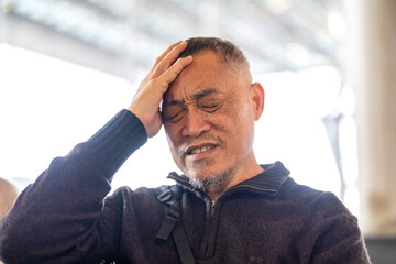 Sick unhappy senior elderly man touching head serious depressed feeling headache thinking of...