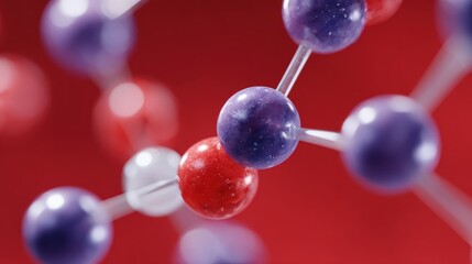 Close-up of a molecular model with red and purple spheres connected by rods on a red background, representing chemical bonds and atomic structure.