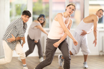Girl makes movements and teaches group of hip hop fans to move beautifully and confidently to...