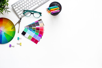 Flat lay of color paint swatches and decorator or designer tools for work on desktop, top view