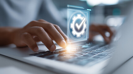 Hands typing on a laptop with a digital icon of a gear and checkmark overlayed on the keyboard