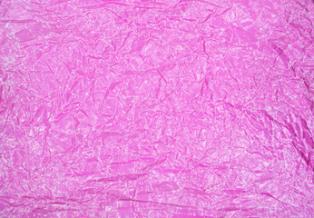 Close-up fragment of a pink magenta crumpled paper texture as a backdrop composition. Crumpled pink paper texture background