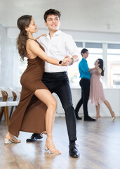 Young man and young woman dance couple latin dances in studio