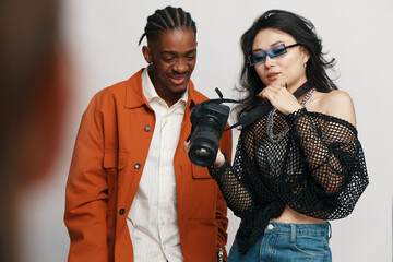 young adult man and woman coworkers socializing at workplace, checking camera, business friends working together in casual style, Gen Z collaboration in office environment