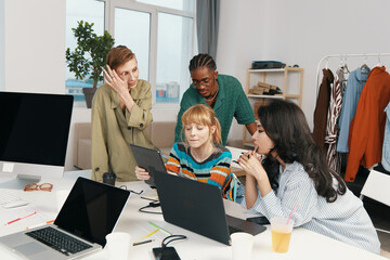 Young adult woman working with colleagues in a modern workplace, socializing and collaborating on a...