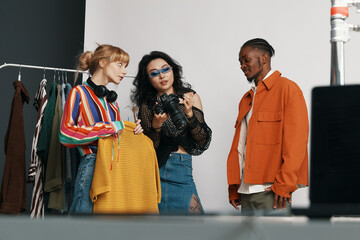 Young adult colleagues socializing at workplace, woman holding camera and friendly coworkers...