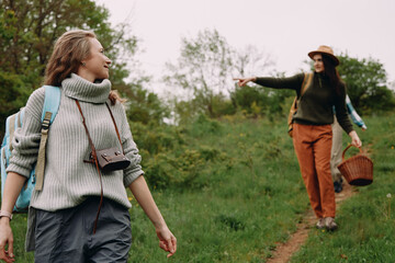 Active middle age woman hiking outdoors in autumn nature with camera and warm clothing embracing...