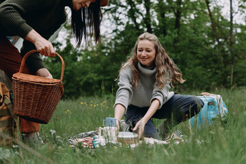 Middle age woman enjoying outdoor picnic with friend in green park, showcasing active and healthy...