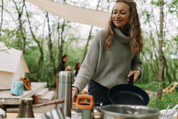 Middle age woman enjoying active healthy lifestyle camping outdoors, embracing wellness and...