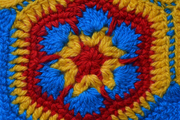 Yellow and red crochet rug. Handmade product made of woolen threads.