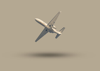A small passenger plane from below isolated on a gray background color, the image looks...