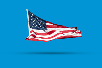 A waving flag of USA isolated on blue background color, the image looks three-dimensional and the...