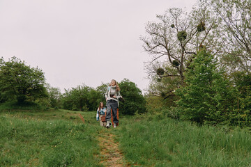 Fototapeta premium Active middle age woman hiking with a backpack on a green trail outdoors, promoting health, wellness, and wellbeing in a natural community setting.