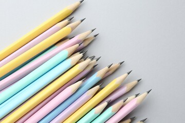 Many graphite pencils on light grey background, flat lay. Space for text