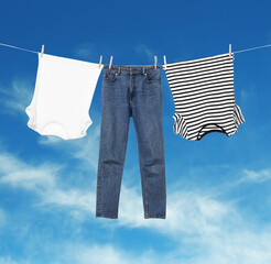 Different clothes drying on washing line against blue sky