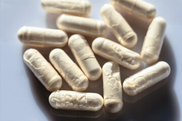  Macro image of white medical capsules containing powdered antibiotics, arranged on a smooth...