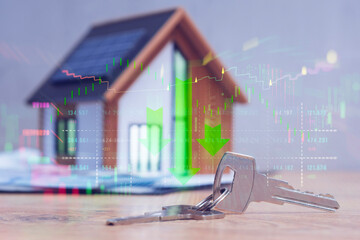House with solar panels, keys, and overlaid falling stock market graph. Concept real estate market downturn and economic crisis.
