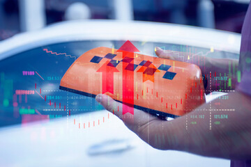 Roof top cab sign held by a man, with digital overlay of financial stock market charts and upward...