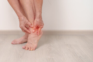 Elderly woman having leg pain due to Ankle Sprains or Achilles Tendonitis and Shin Splints ache....