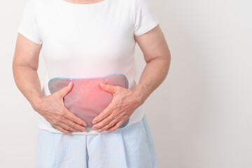 Elderly woman having abdomen aches with Hot Water Bottle Bag for Pain Relief for Stomach pain,...