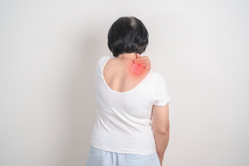 Elderly Woman having Shoulder Pain with Medicated pain relief patch plaster for Muscle Inflammation...