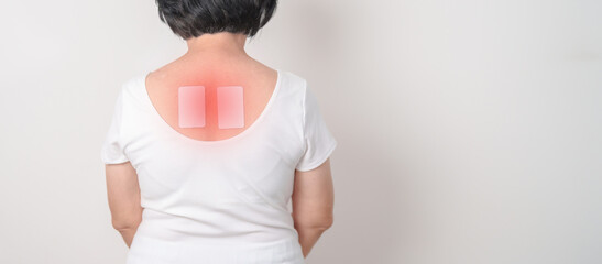 Business woman having back ache with Medicated pain relief patch plaster for Back Muscle Strain,...
