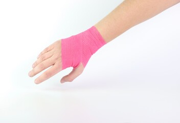 Woman hand with a pink cohesive bandage isolated in a white background