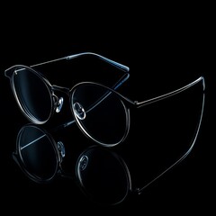 black eyeglasses, frame temples are open, standing on a black background, perspective is 45 degree angle
