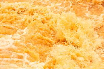 Orange water with ripples on the surface. Defocus blurred transparent blue colored clear calm water...