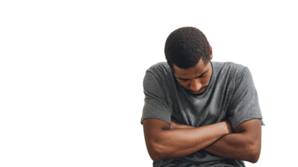 Young man in a gray t-shirt, sitting with arms crossed, displaying a thoughtful expression.
