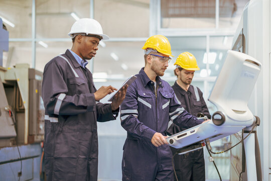 High tech factory caucasian engineer uses computer for programming pick and place surface mount electronic machinery for printed circuit board assembly line. AI Robotic arms manufacturer.