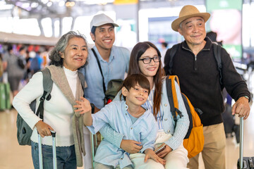 Asian multigenerational family at airport traveling with kids and grandparents, joyful moments of...