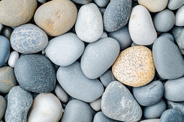 A collection of smooth rounded pebbles in various shades of gray and tan