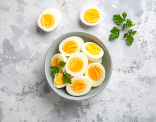 Boiled egg slices in bowl: Sliced hard-boiled eggs, showcasing vibrant yellow yolks, artistically arranged in a bowl and adorned with fresh parsley sprigs, against a textured surface.