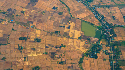Fototapeta premium Aerial view Green paddy rice terrace land. Aerial drone shots summer tropical in summertime on sunny day amazing landscape. Agriculture rice field above view greenery background natural paddy fields