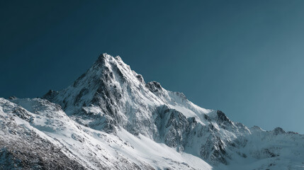 Snowy mountain peak under clear blue sky with bright natural light