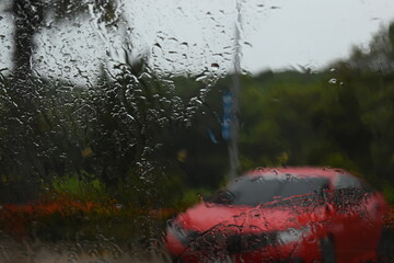 red car on parking in raining day, abstract blur background