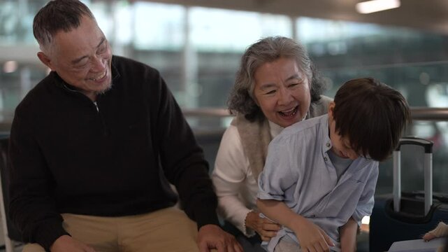 Asian multigenerational family at airport traveling with kids and grandparents, joyful moments of vacation, family holiday trip with luggage before flight, tour, friendly airline, hotel for families